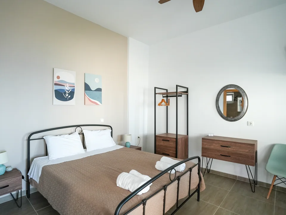Double bed with bedside tables, mirror and framed prints