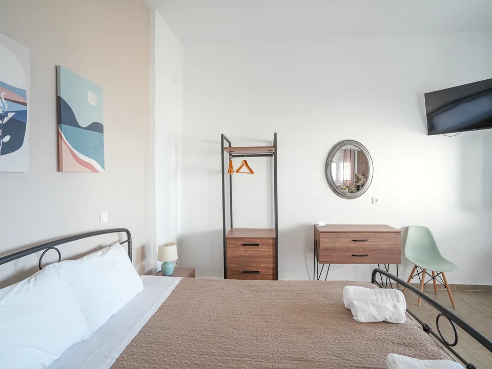 Double bed with clothes rail and wall-mounted television