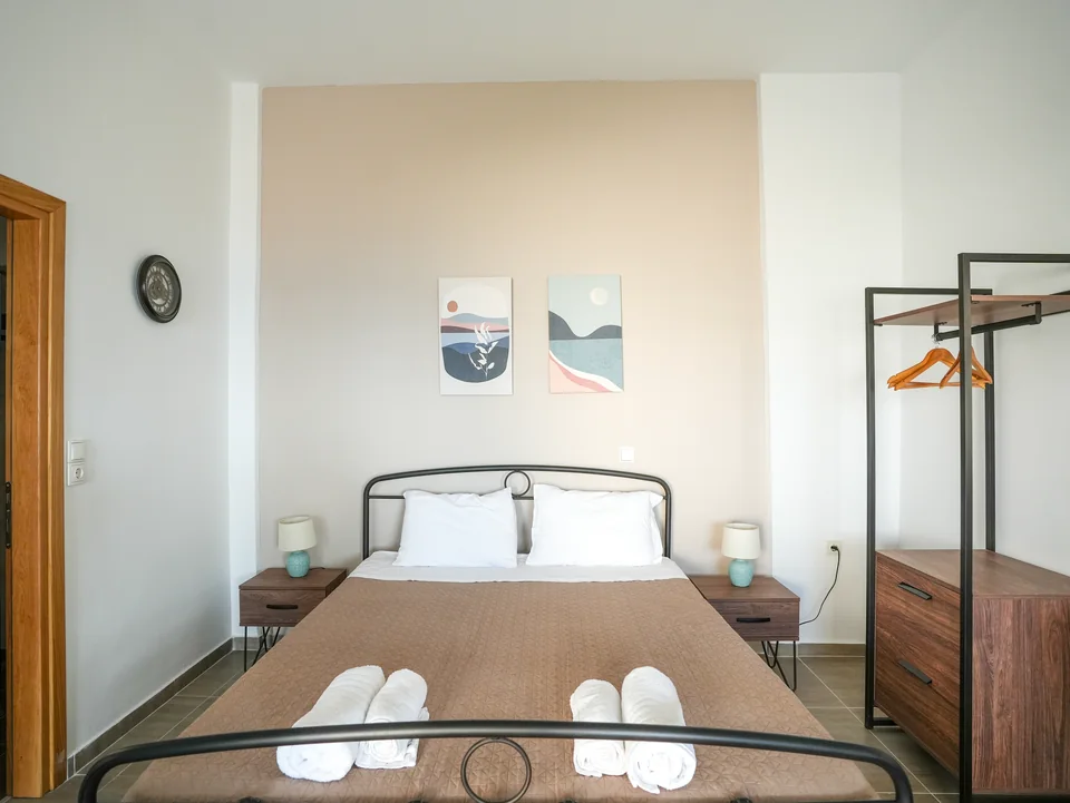 Double bed with folded towels and hanging space