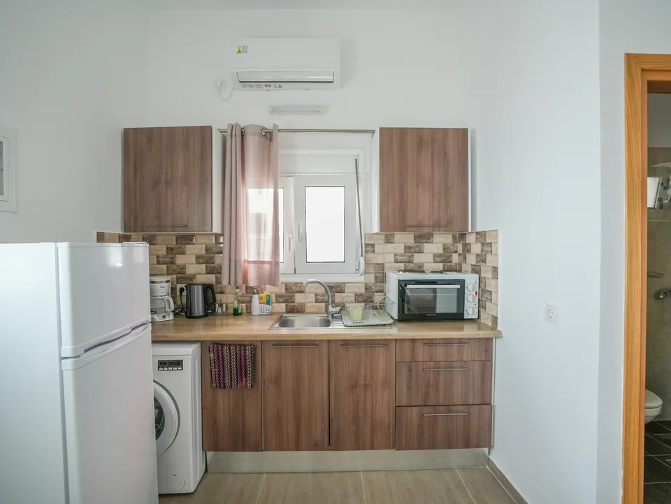 Kitchenette with fridge, washing machine, kettle and microwave