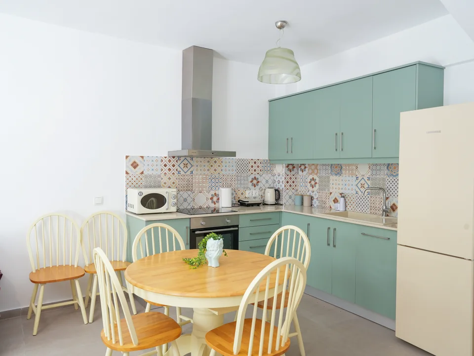 Fitted kitchen with dishwasher, oven and round dining table