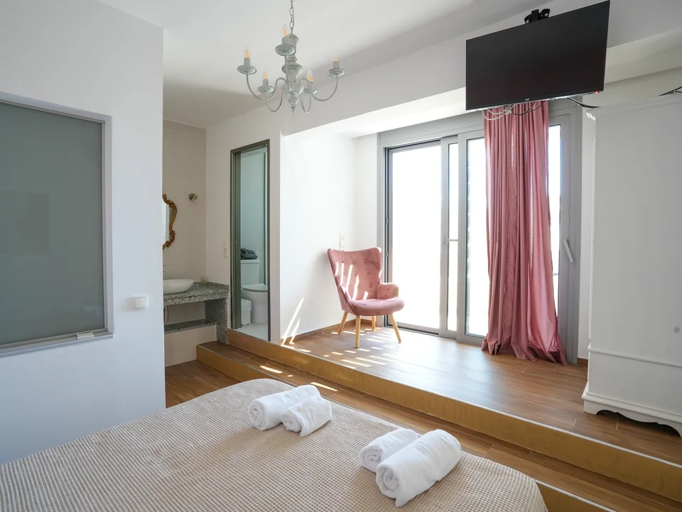 Double bedroom with wall-mounted television and balcony access