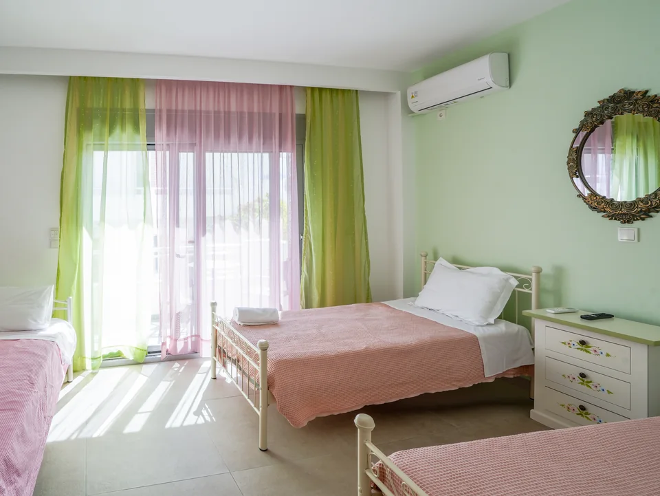 Twin bedroom with green curtains and a dressing table