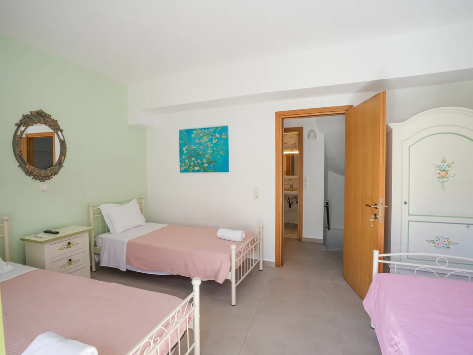 Twin bedroom with framed artwork and doors to the landing