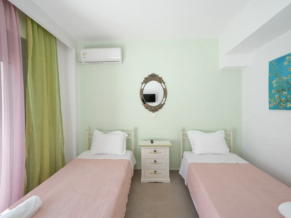 Twin bedroom with mirror and pastel walls