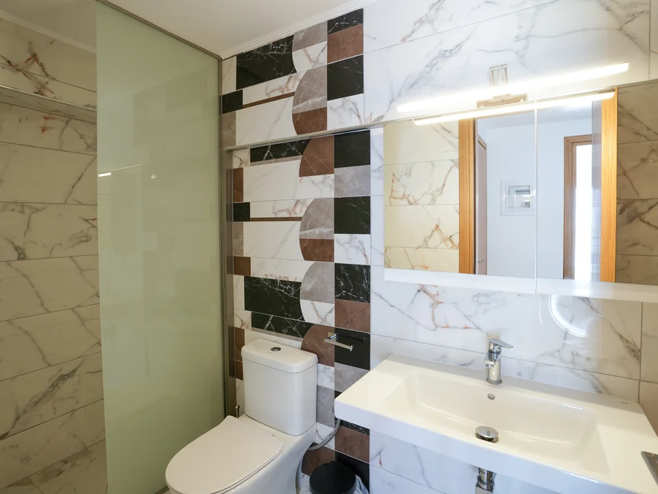 Marble bathroom with a large mirror and washbasin