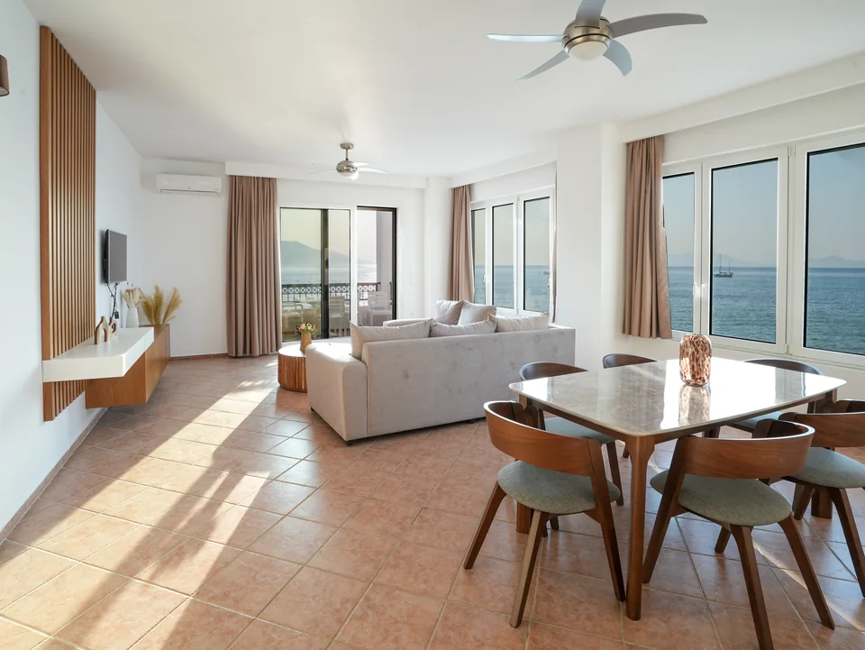 Open-plan living room with dining table and sea views on three sides