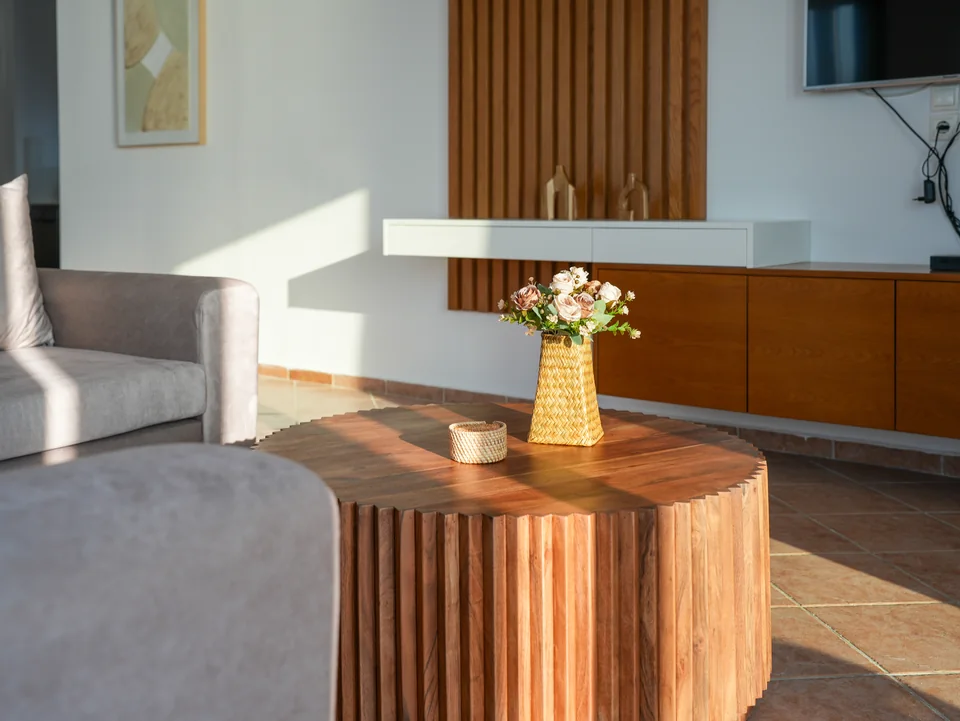Detail of the ribbed wooden coffee table and armchair in the living room