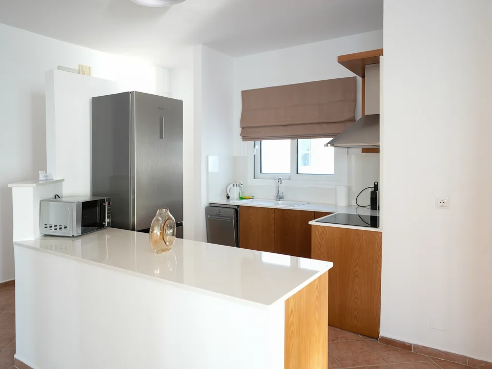 Modern kitchen with island, fridge and wooden cabinetry