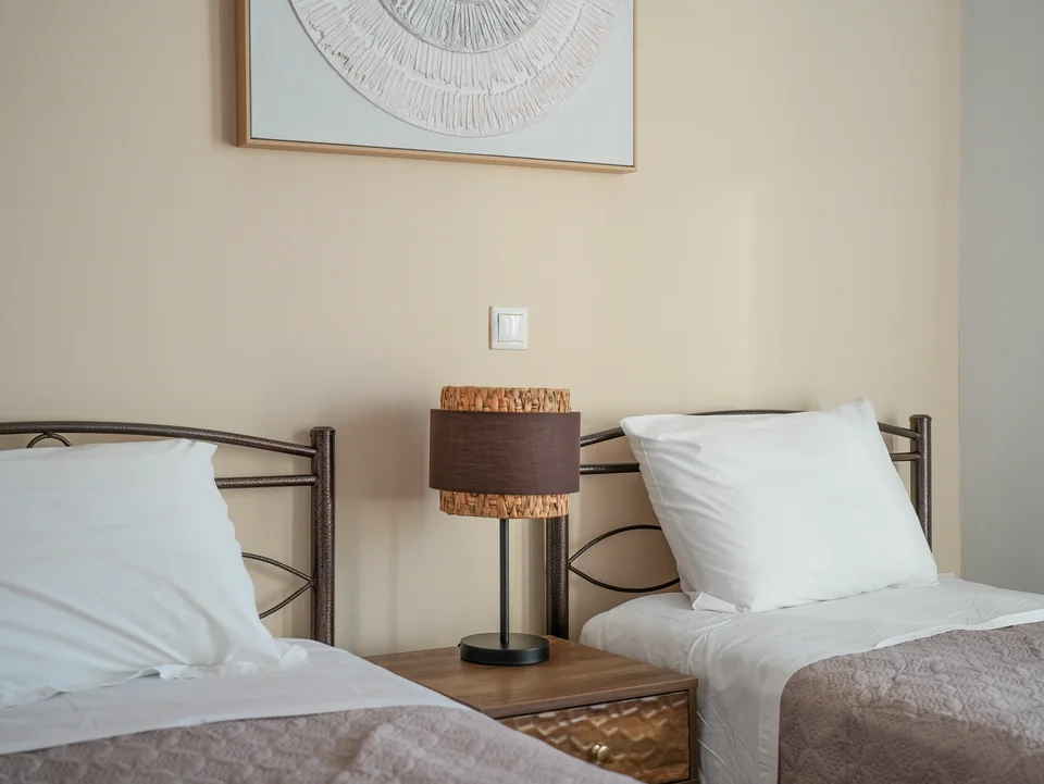 Twin bedroom with wrought-iron beds and bedside lamps