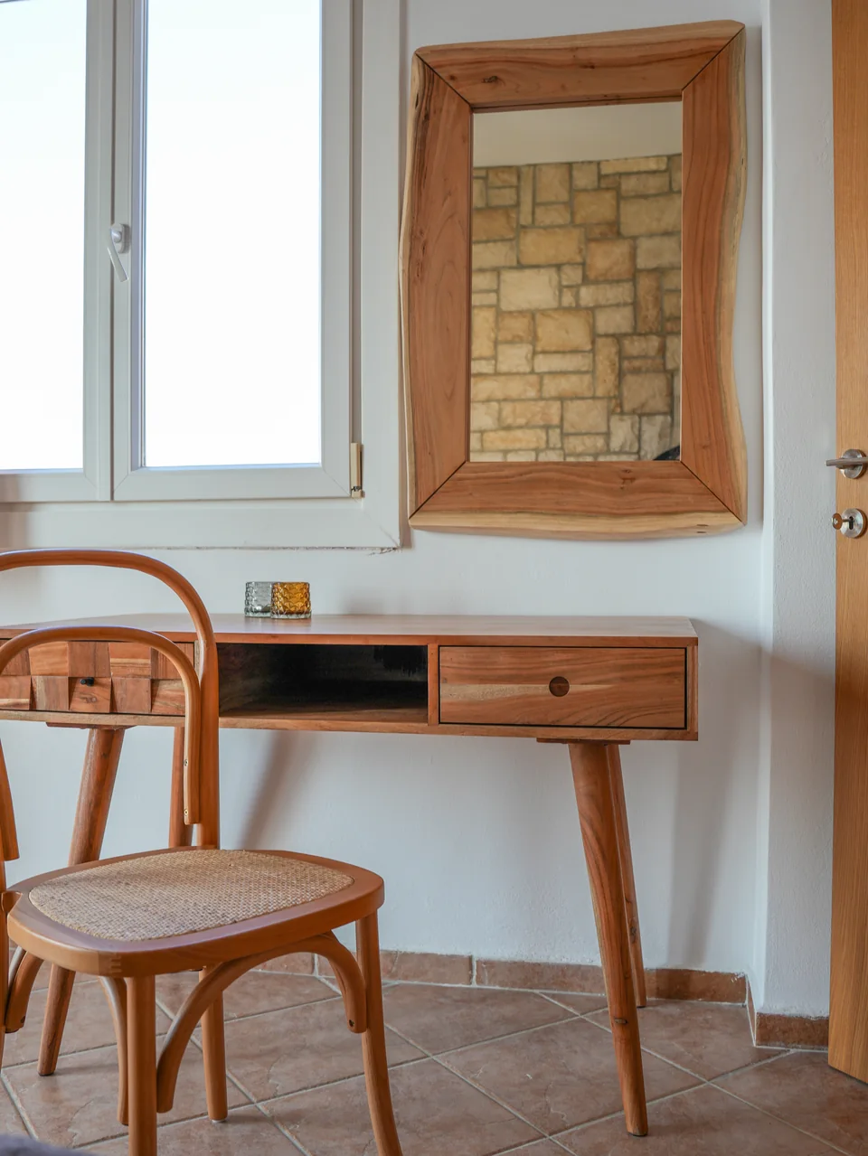 Writing desk and chair beneath a mirror