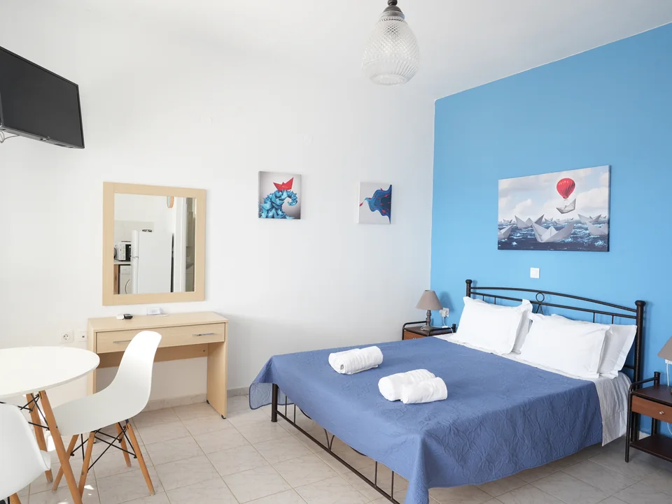 Double bed with folded towels, mirror and desk
