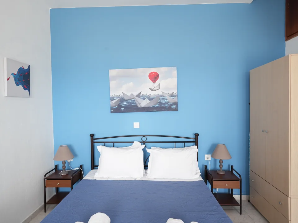 Double bed against the blue feature wall with bedside lamps