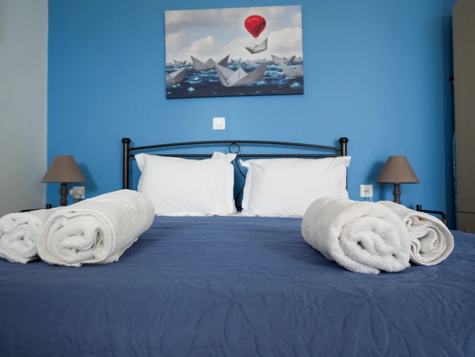 Double bed made up with white linen and folded towels