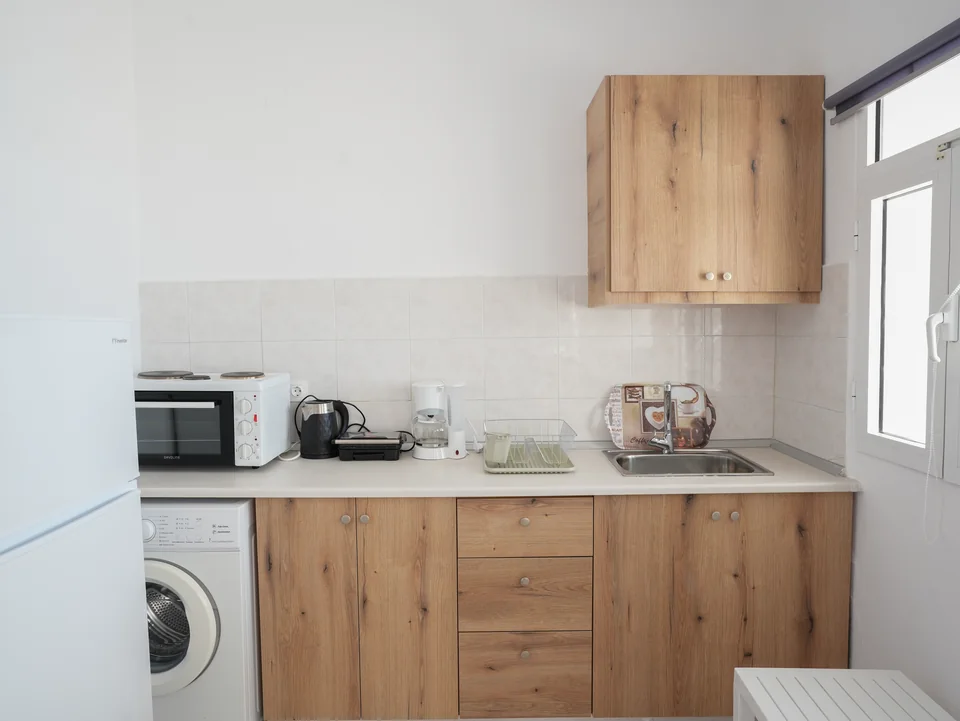 Kitchenette with washing machine, microwave and sink
